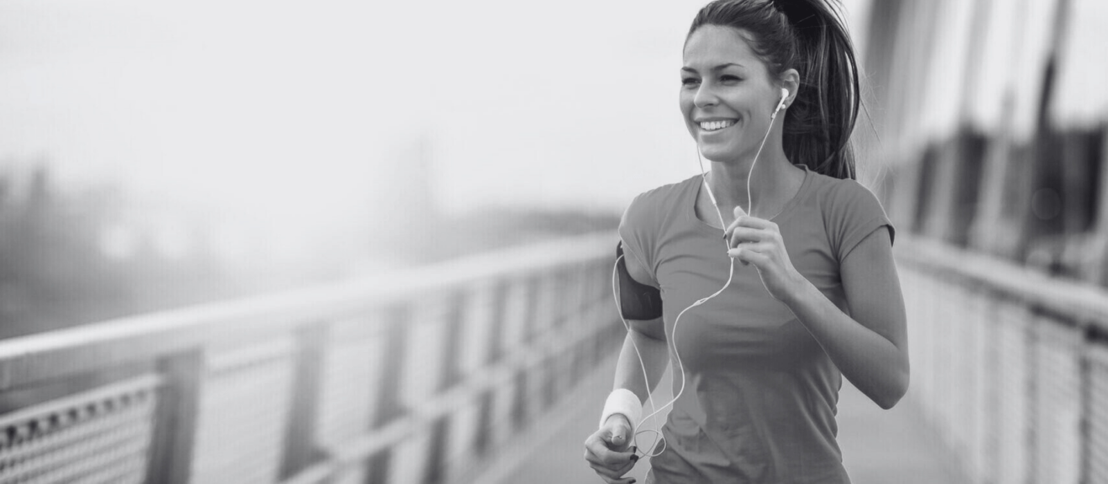 Young woman jogging outdoors on bridge. Concept of healthy lifestyle.