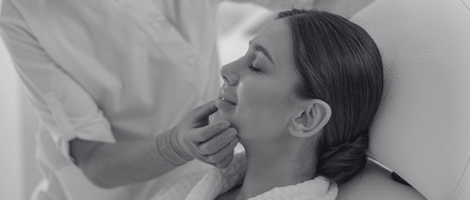 black and white photo of woman receiving a facial treatment